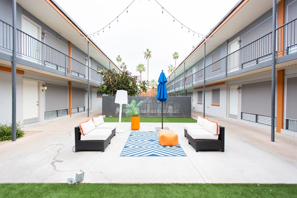 a courtyard with couches and a rug in a building