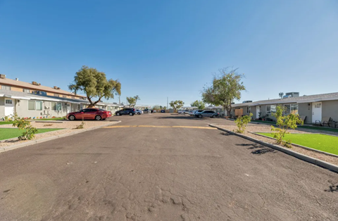 a parking lot with houses on both sides of it