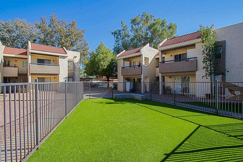 the outlook of a yard with a fence and apartment buildings