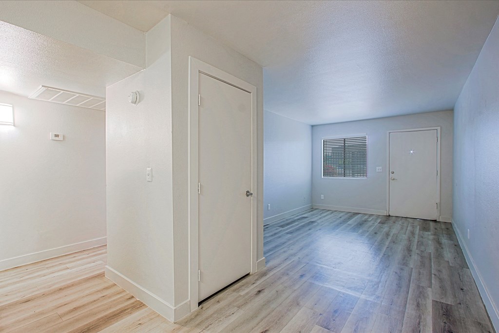 a bedroom with hardwood floors and white walls