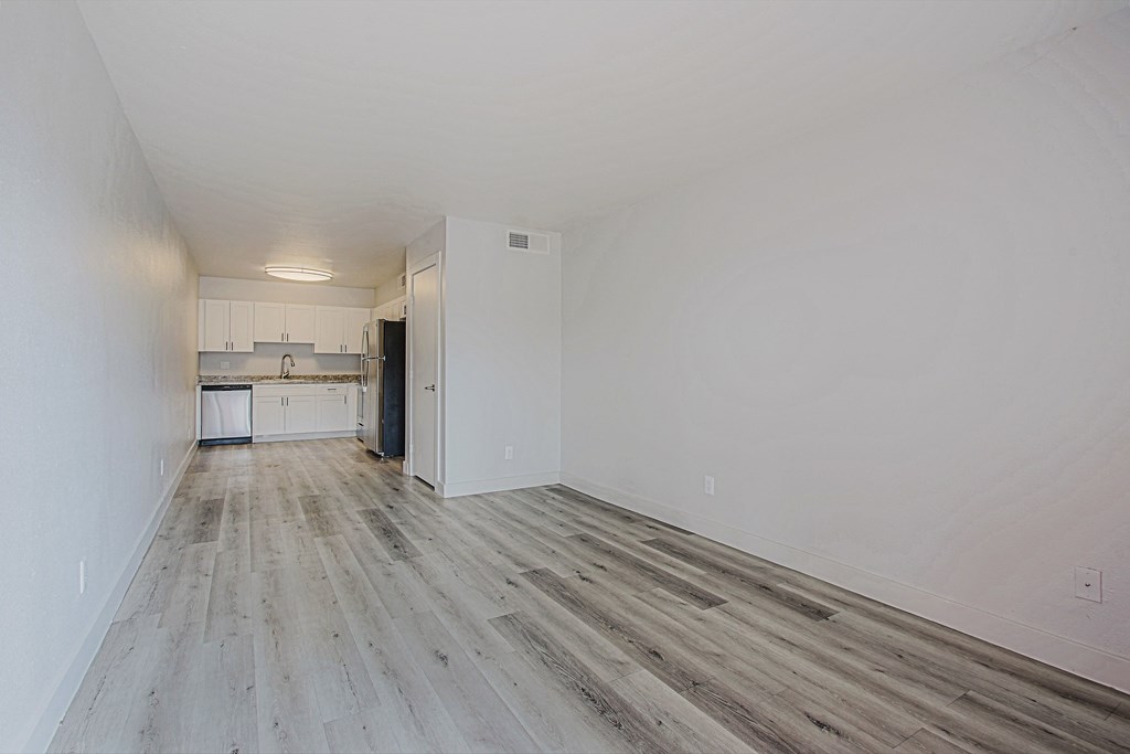 a bedroom with hardwood floors and white walls