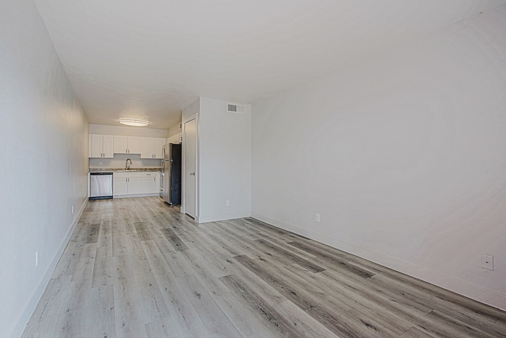 a bedroom with hardwood floors and white walls