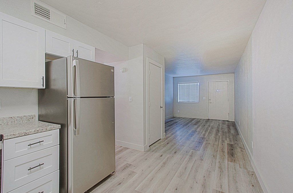 a kitchen with white cabinets and a stainless steel refrigerator