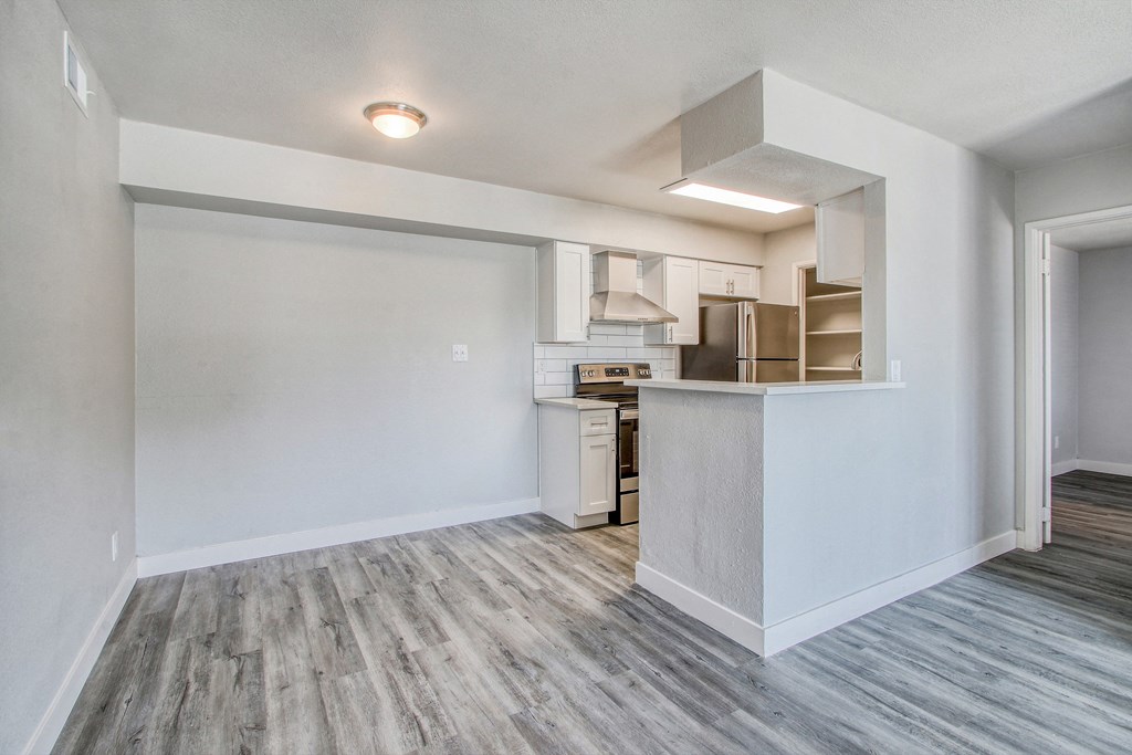 an empty living room and kitchen with a counter top and
