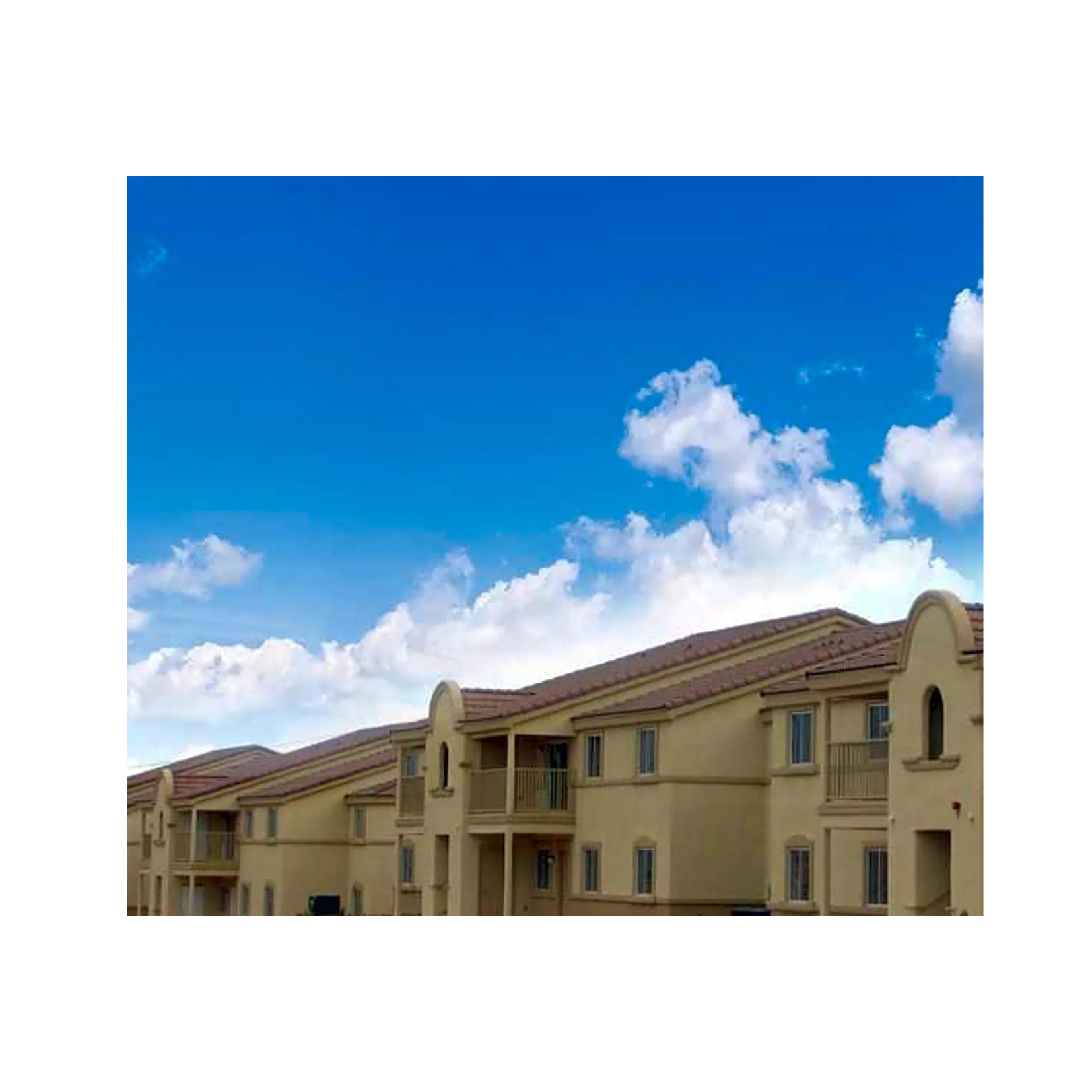 an image of an apartment building with a blue sky in the background