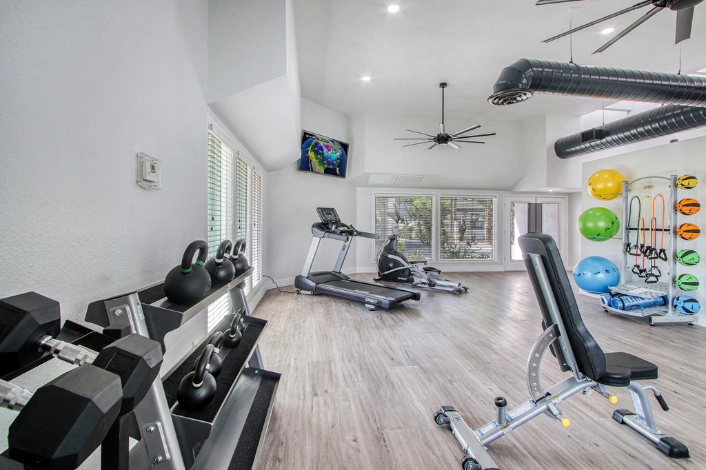 a gym with weights and other exercise equipments and a window