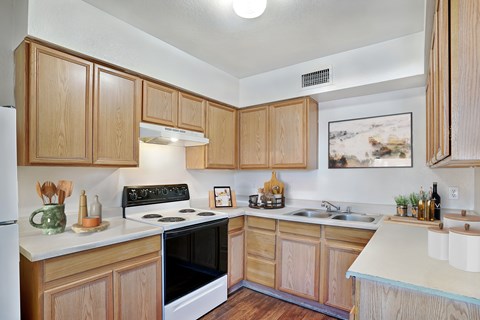 A kitchen with wooden cabinets and a black stove top oven.