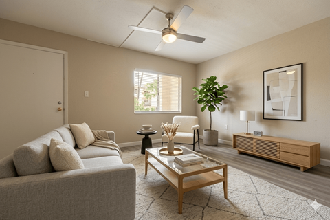 A living room with a grey couch, a wooden coffee table, and a ceiling fan.