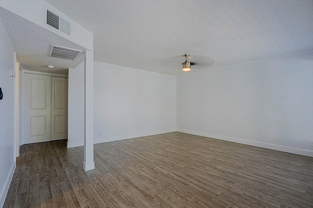 A room with wooden flooring and white walls.