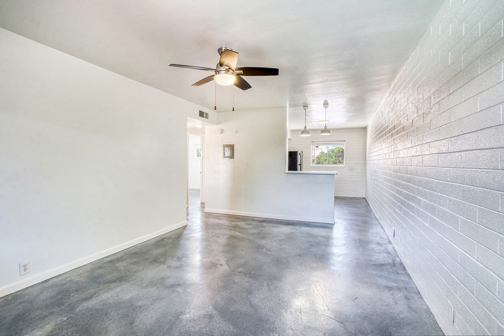 a living room with white walls and a ceiling fan