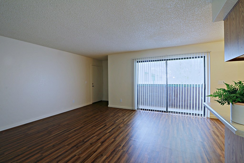 a living room with hardwood floors and a large window