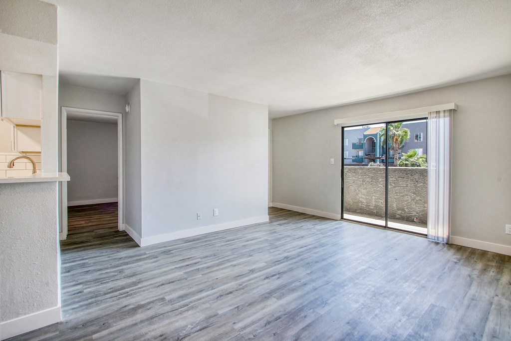 an empty living room with a sliding glass door to a patio