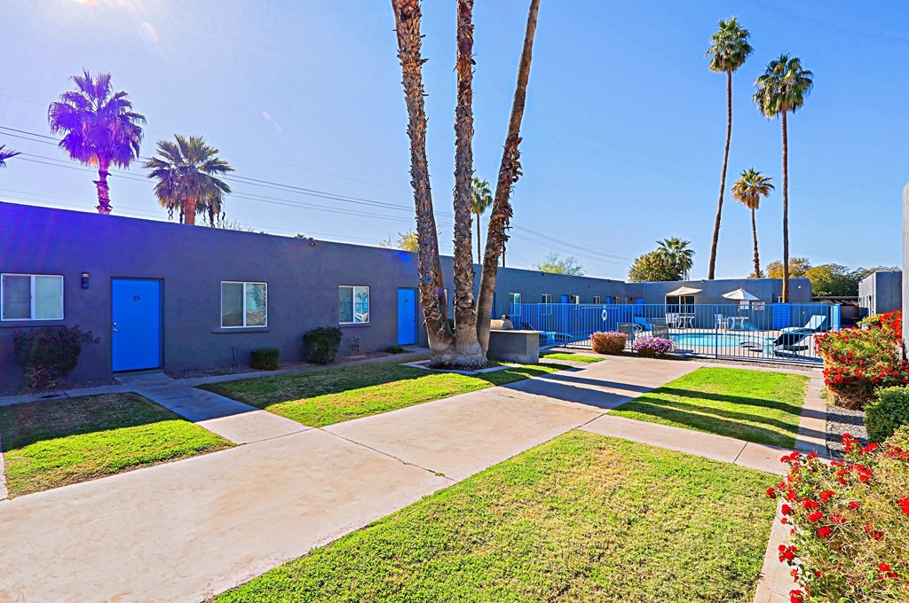 A blue building with a concrete walkway in front of it.