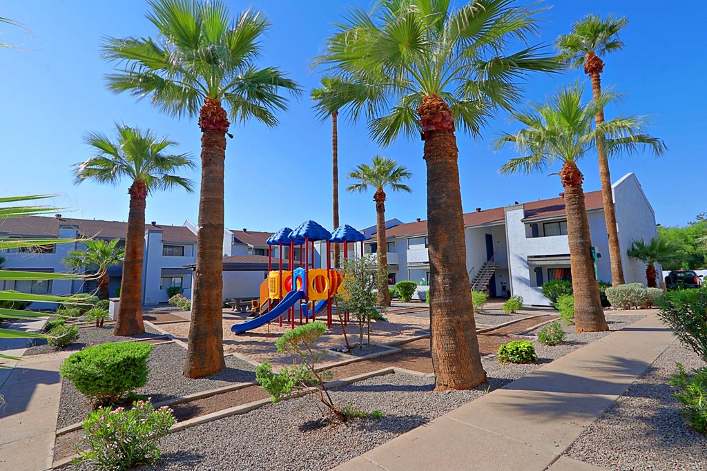 a playground and palm trees in front of a building