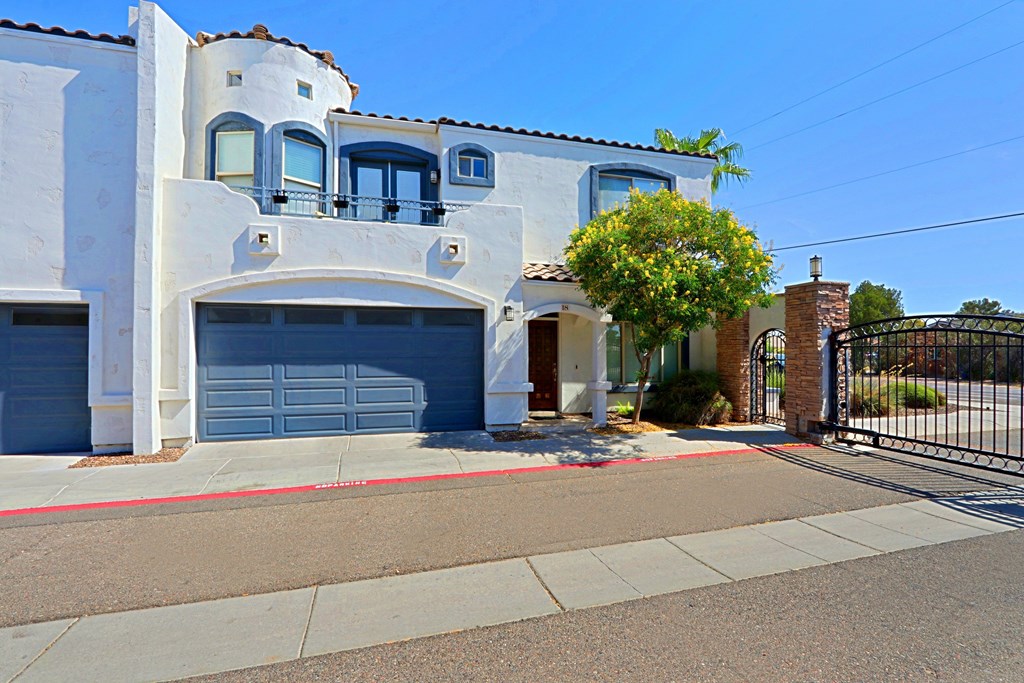 A white house with a red stripe on the sidewalk.