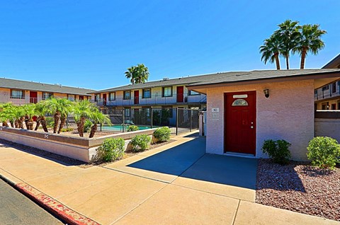 A red door is on the right side of a building.