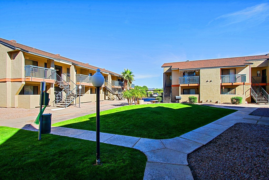 an exterior view of apartments with a yard and grass