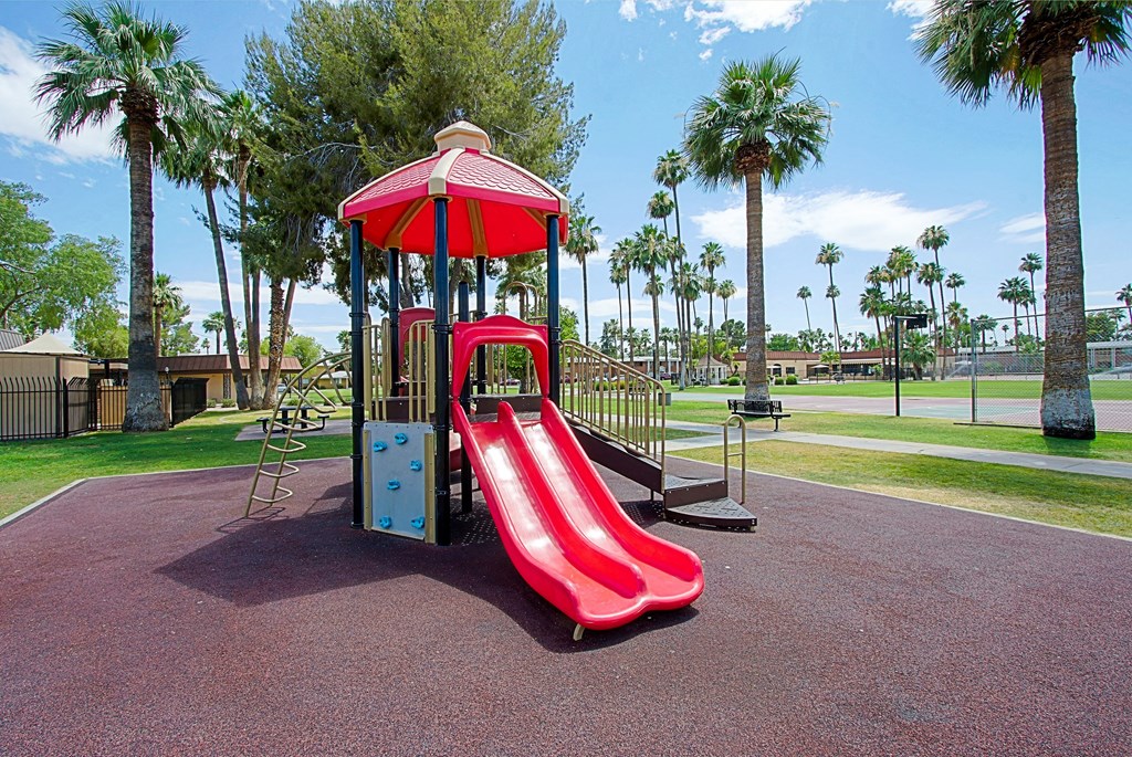 a playground with a red slide and monkey bars