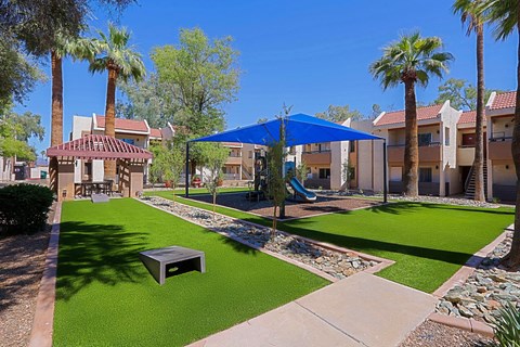 A sunny day at the community park with a gazebo and a playground.