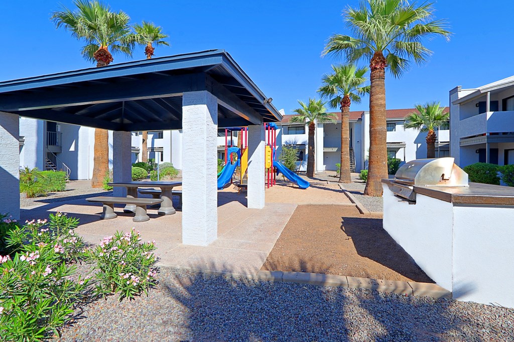 a playground and picnic area at a resort with palm trees