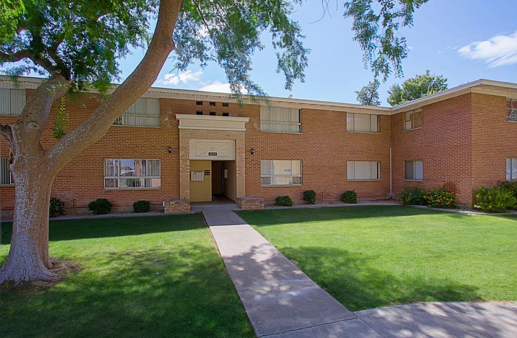 a large brick building with a lawn in front of it