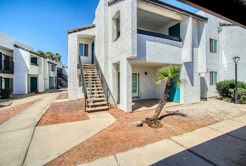 a building with stairs and a palm tree in front of it