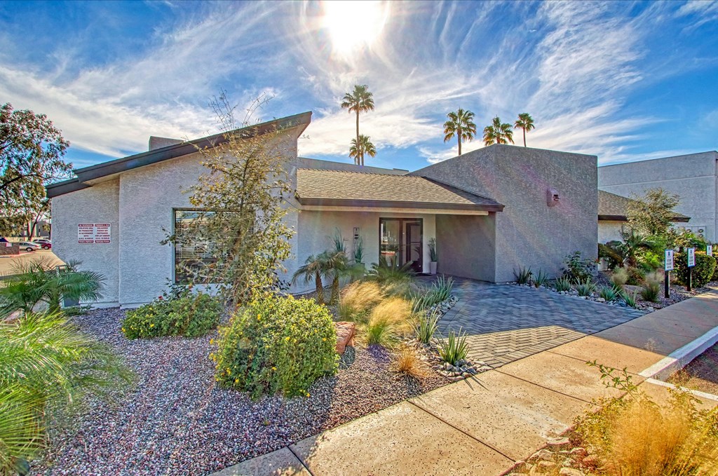 a house with a driveway and plants in front of it