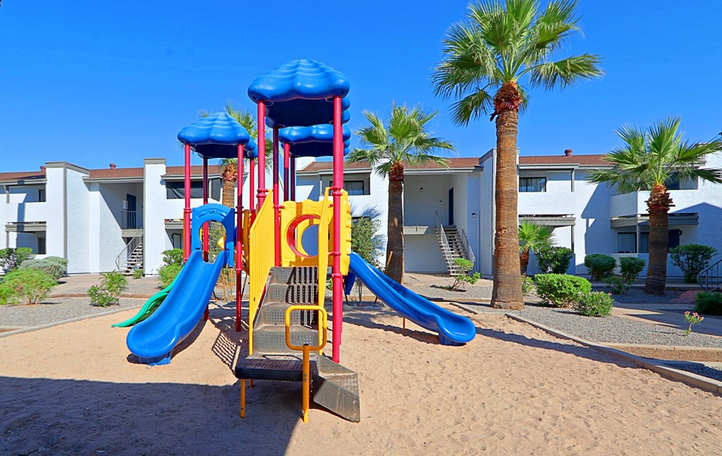 a playground at the resort in the sand with slides