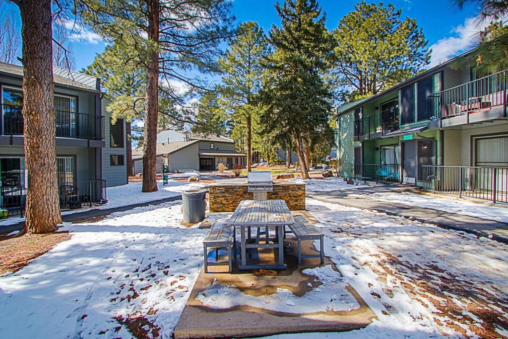 a picnic table in the snow in a courtyard between two apartment buildings
