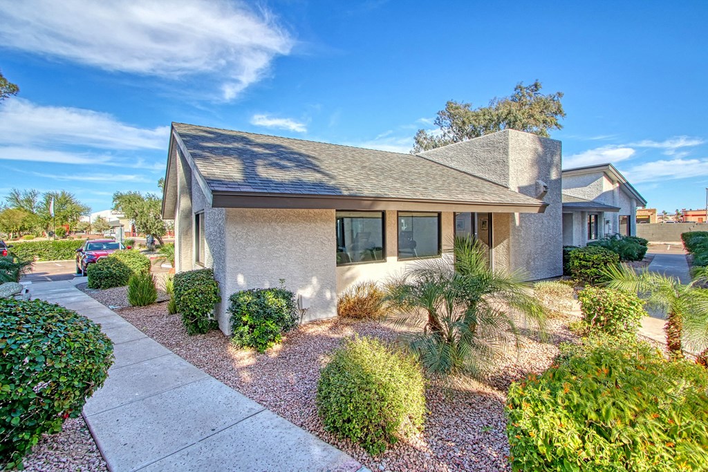 a small house with a sidewalk and landscaping in front of it