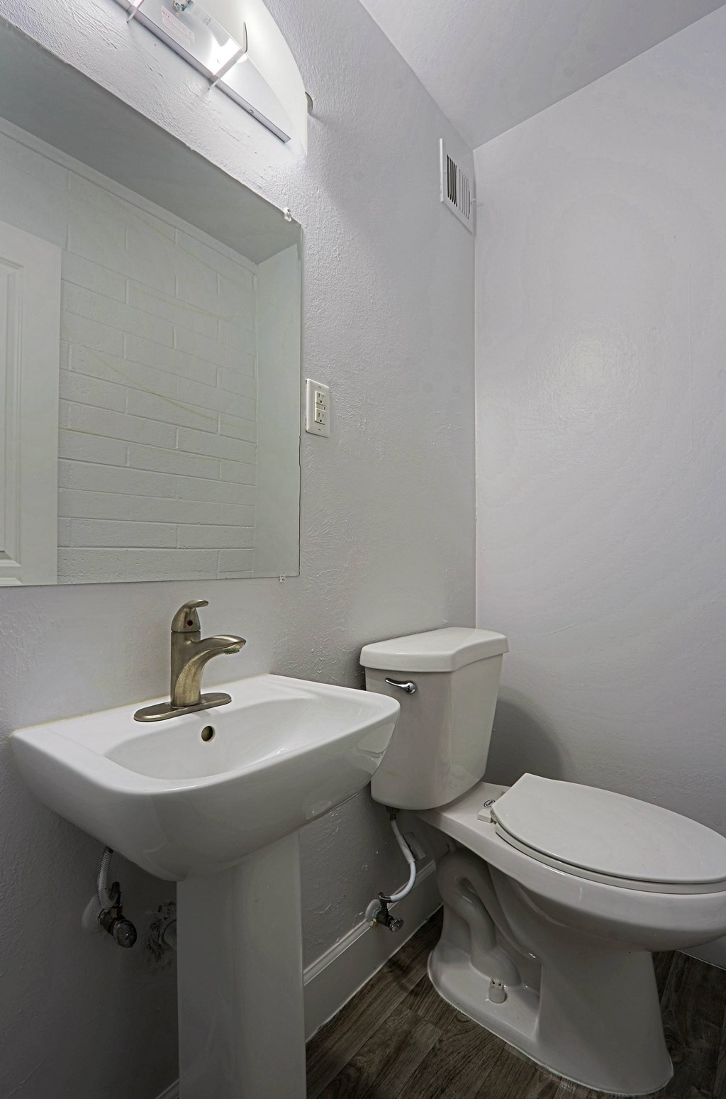 A white sink and toilet in a small bathroom.