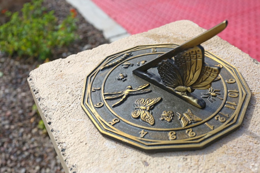 a bronze sundial on top of a rock