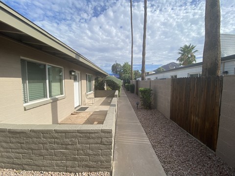 A residential area with a house, a fence, and a tree.
