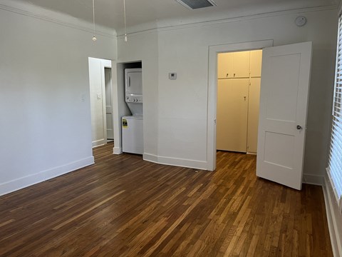 an empty living room with wood flooring and white walls