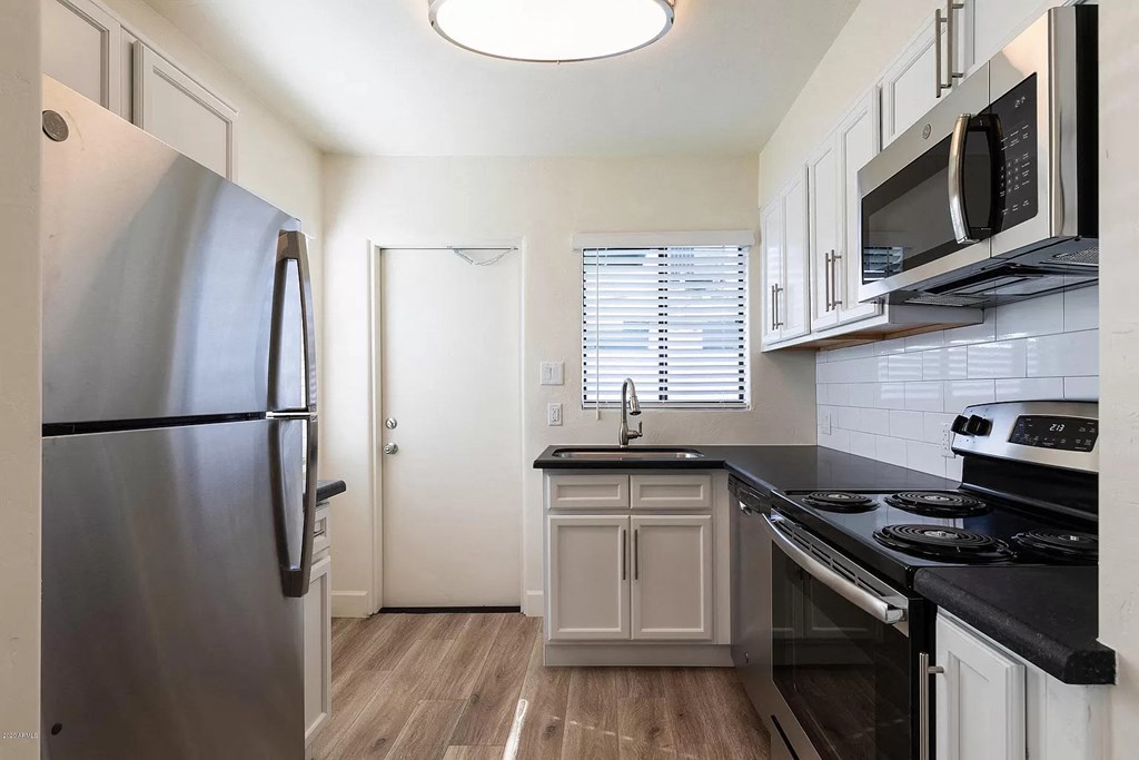 a kitchen with stainless steel appliances and white cabinets