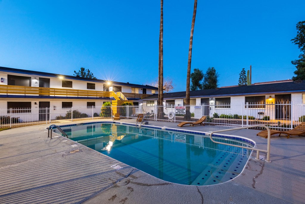 A swimming pool in a resort at dusk.