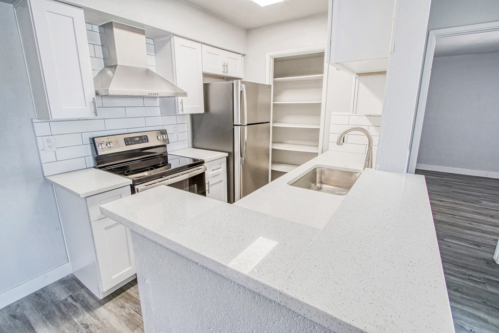 a kitchen with white cabinets and stainless steel appliances