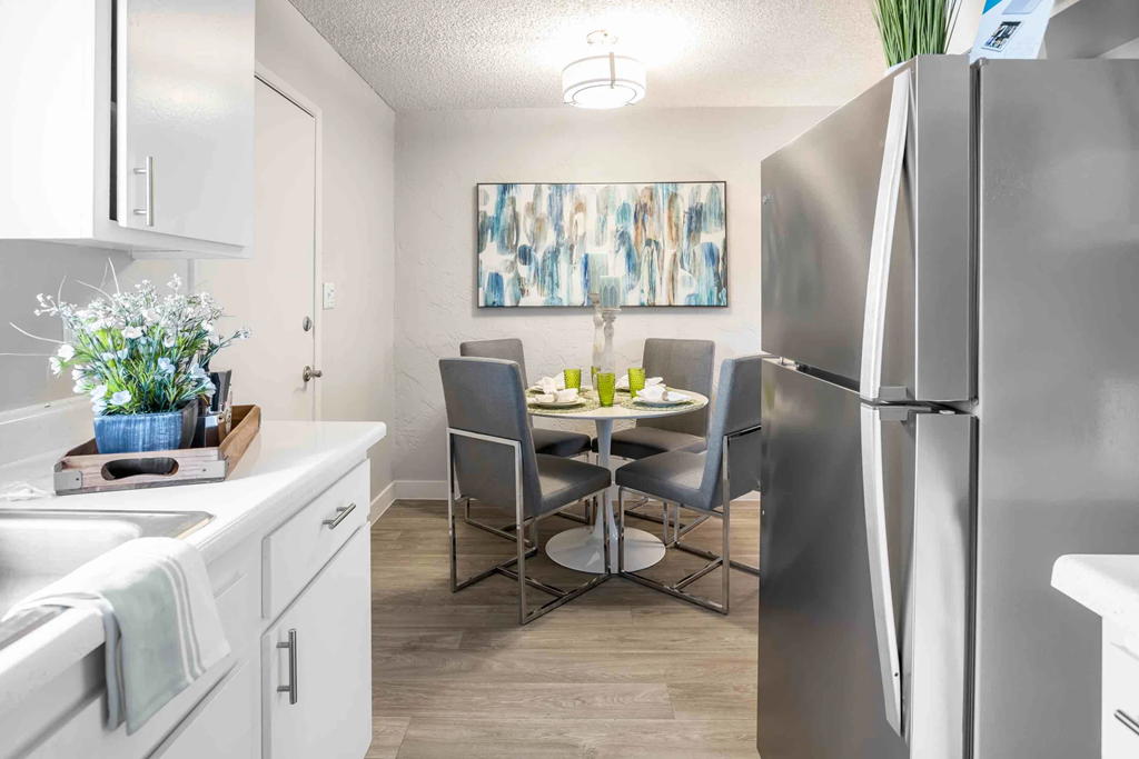 a kitchen and dining room with stainless steel appliances and a table and chairs