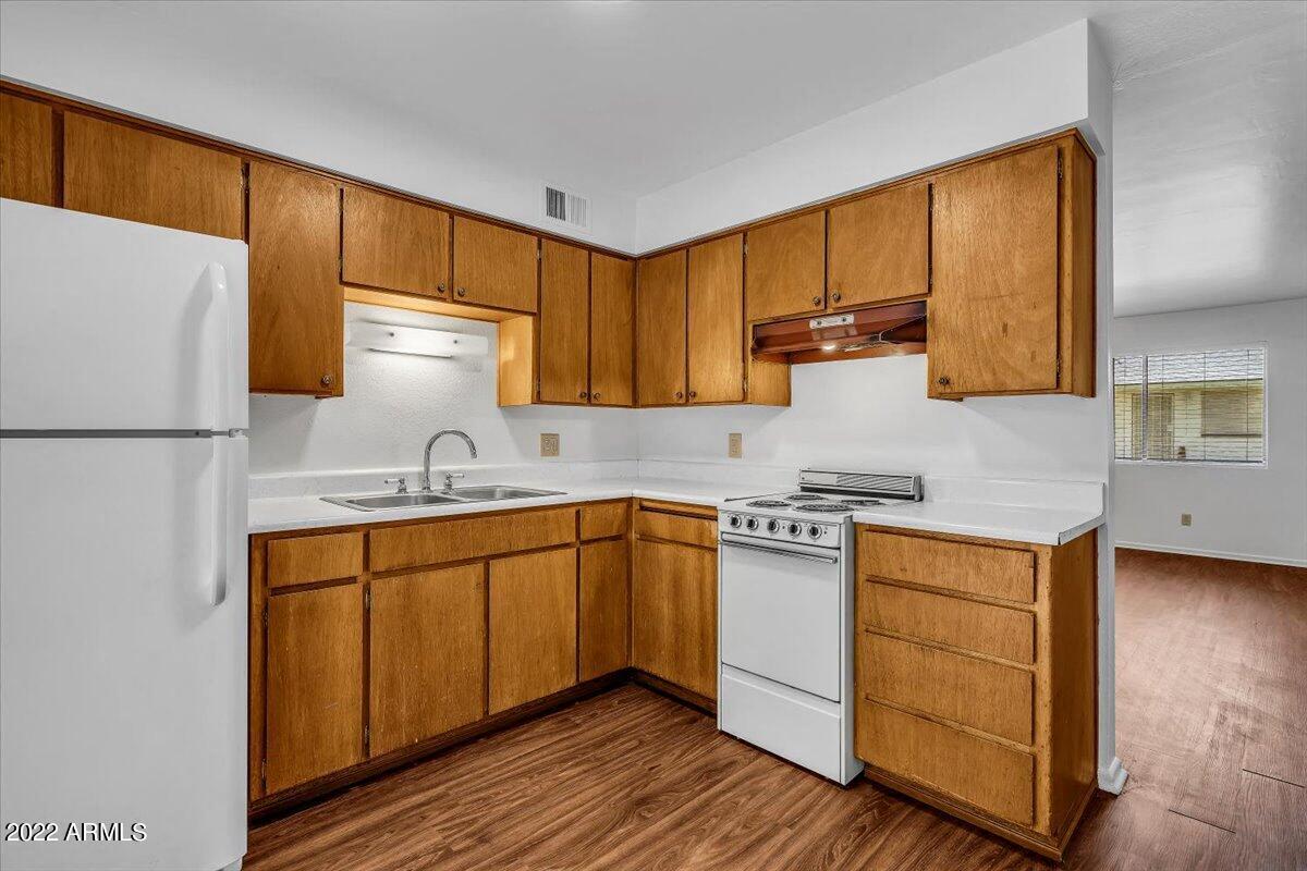A kitchen with wooden cabinets and white appliances.