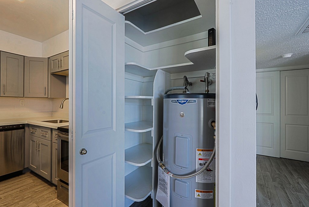 A white door is open to a kitchen with a stainless steel refrigerator.
