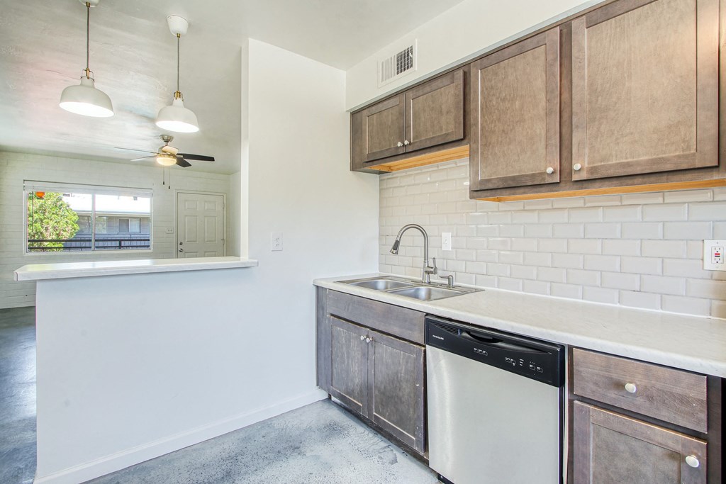 a kitchen with white walls and wooden cabinets