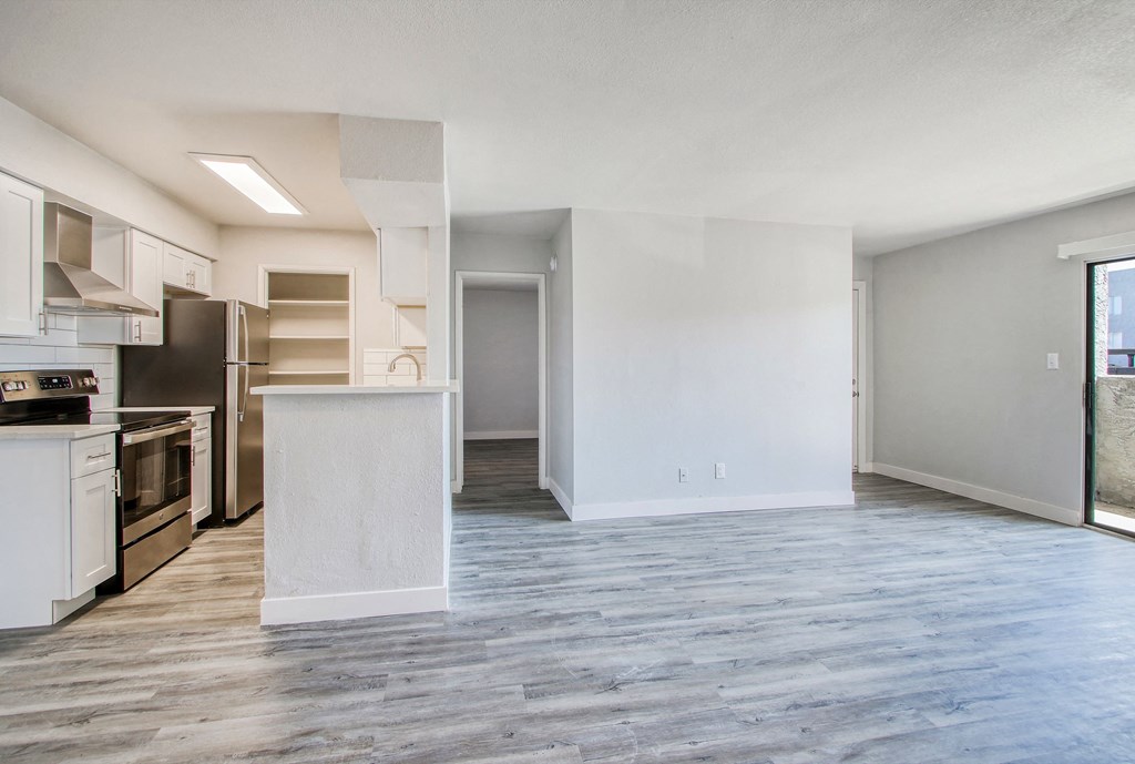 an empty apartment with a kitchen and a living room