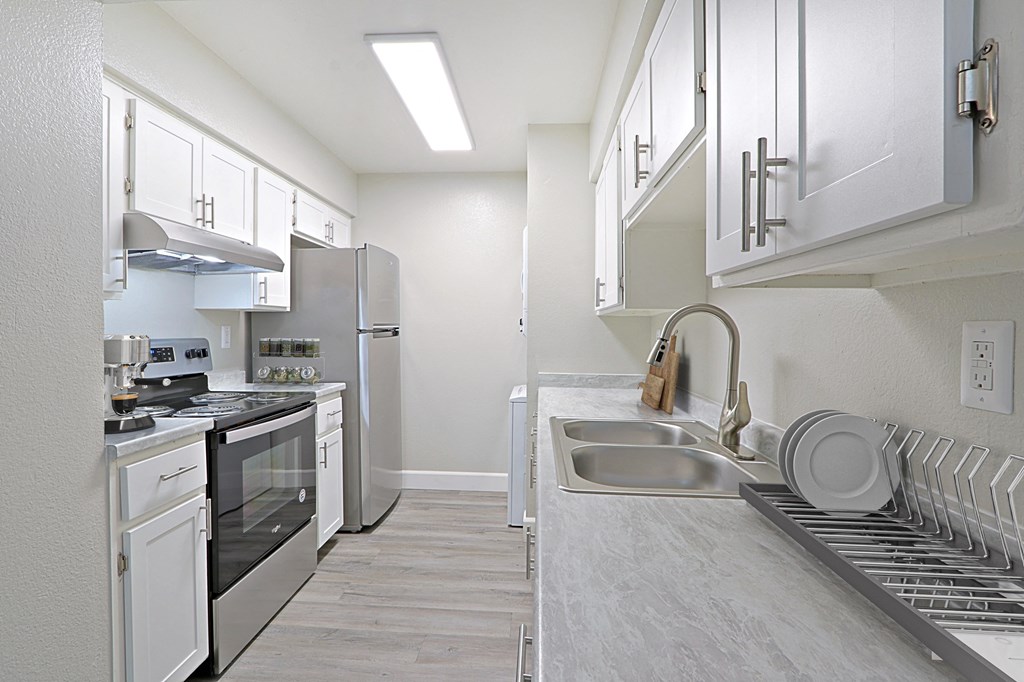 a spacious kitchen with stainless steel appliances and white cabinets