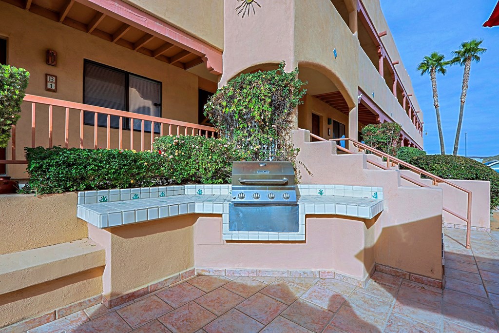 A patio with a grill and a wall.