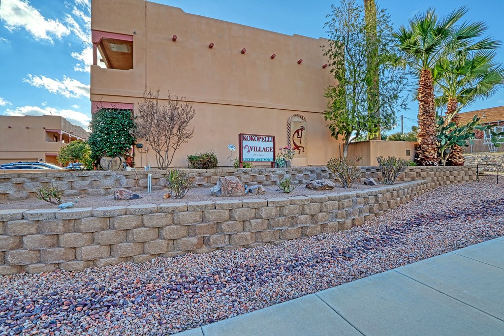a retaining wall with plants in front of a building