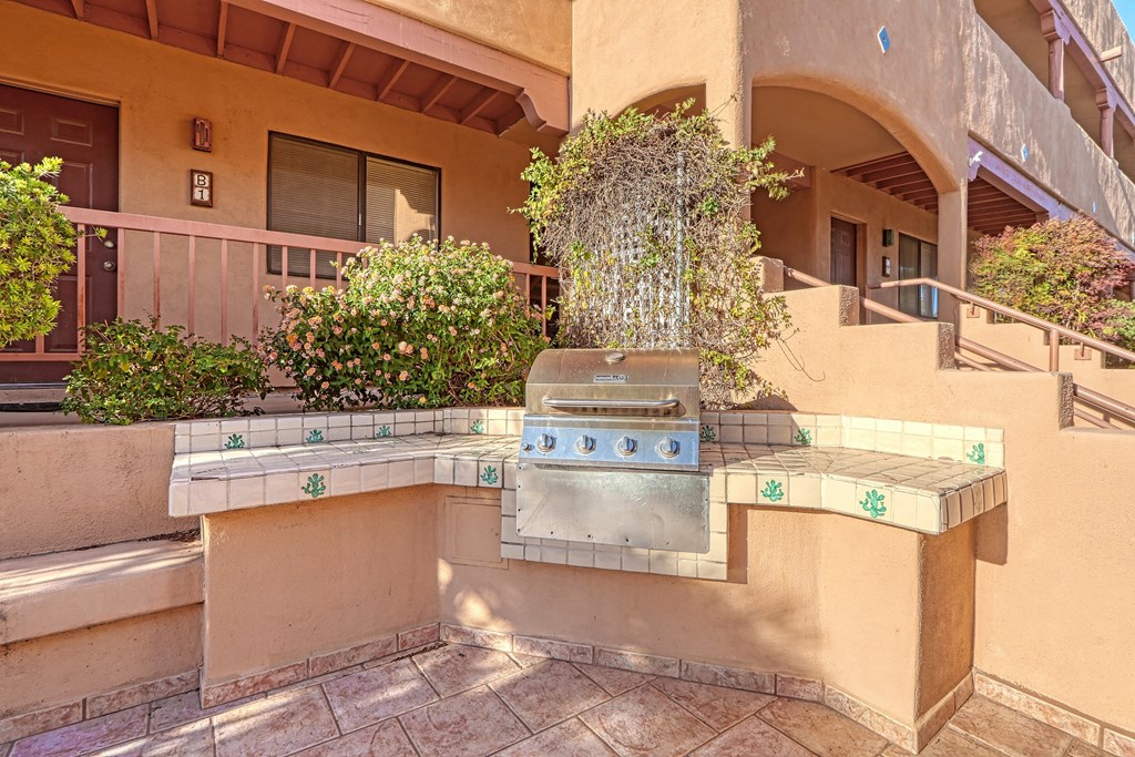 a barbecue grill is in the middle of a patio
