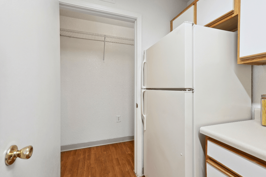 a kitchen with white cabinets and a white refrigerator