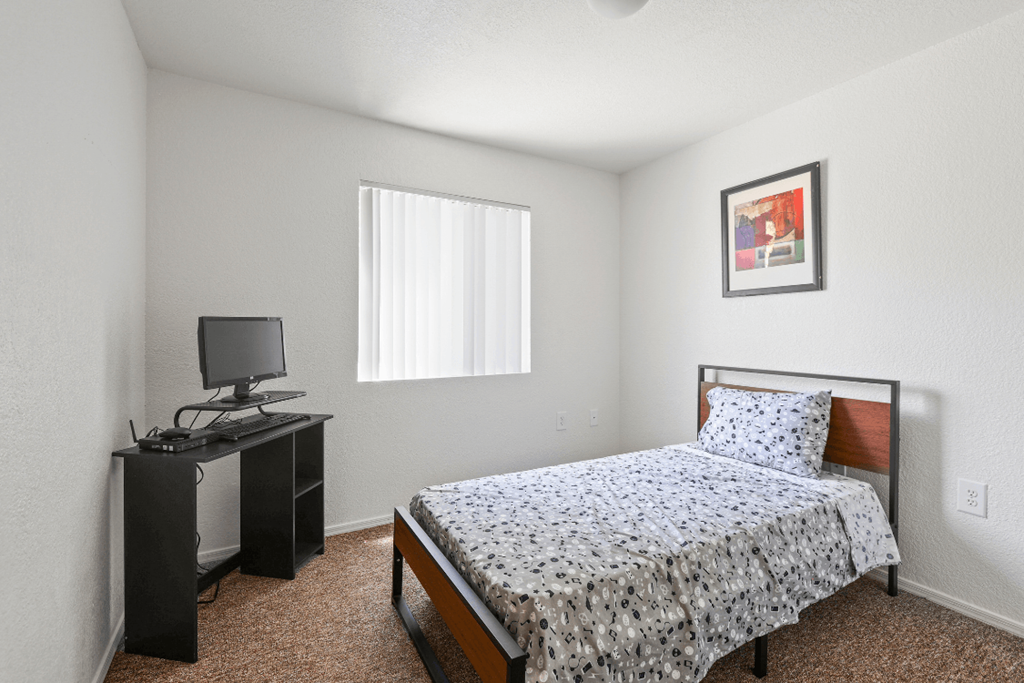 a bedroom with a bed and a desk