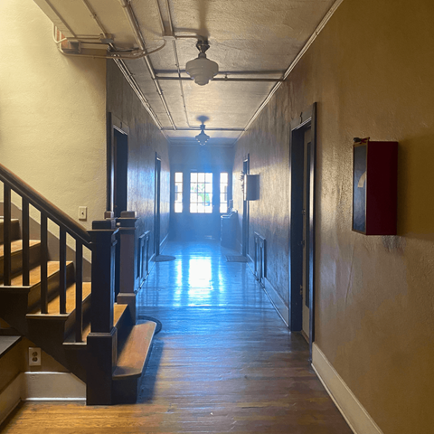 a hallway with wood floors and a wooden staircase