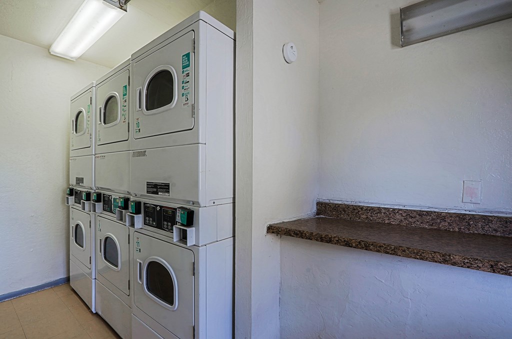 A row of washing machines in a laundry room.